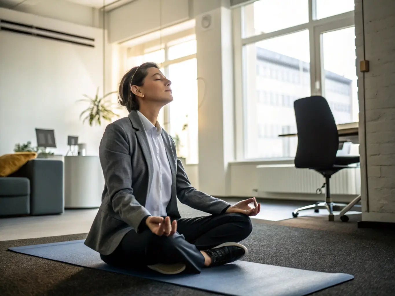 An image of a person meditating in a business setting, representing the mindset development aspect of the coaching services.